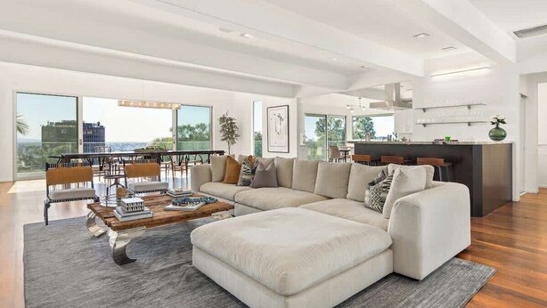 A spacious living room with a large sectional sofa, a coffee table, and a dining area with chairs. - Villa Lareira (Los Angeles)