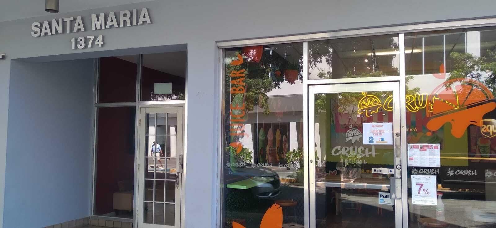 La façade du restaurant Santa Maria, situé au 1374, se distingue par une porte vitrée ornée d’une enseigne indiquant « CRUSH » et par une enseigne néon qui fait la publicité de l’« heure joyeuse ».