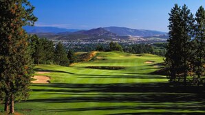 A golf course with a view of a town and mountains in the background. - Cozy Escape with Incredible Lake and Vineyard Views - Sleeps Up to 4 (Kelowna)
