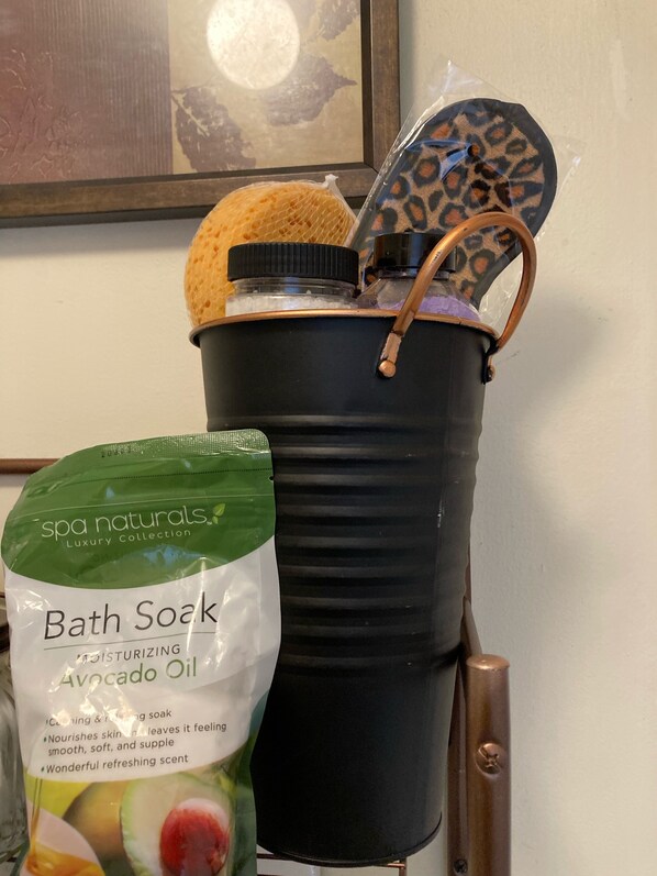 A spa bath tub with a bag of bath soak and a leopard print bath brush. - Close to Yale (New Haven)