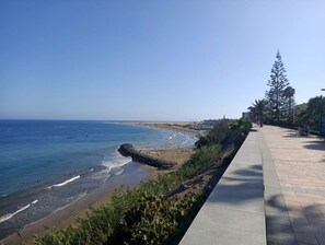 A coastal walkway with a view of the beach and ocean.