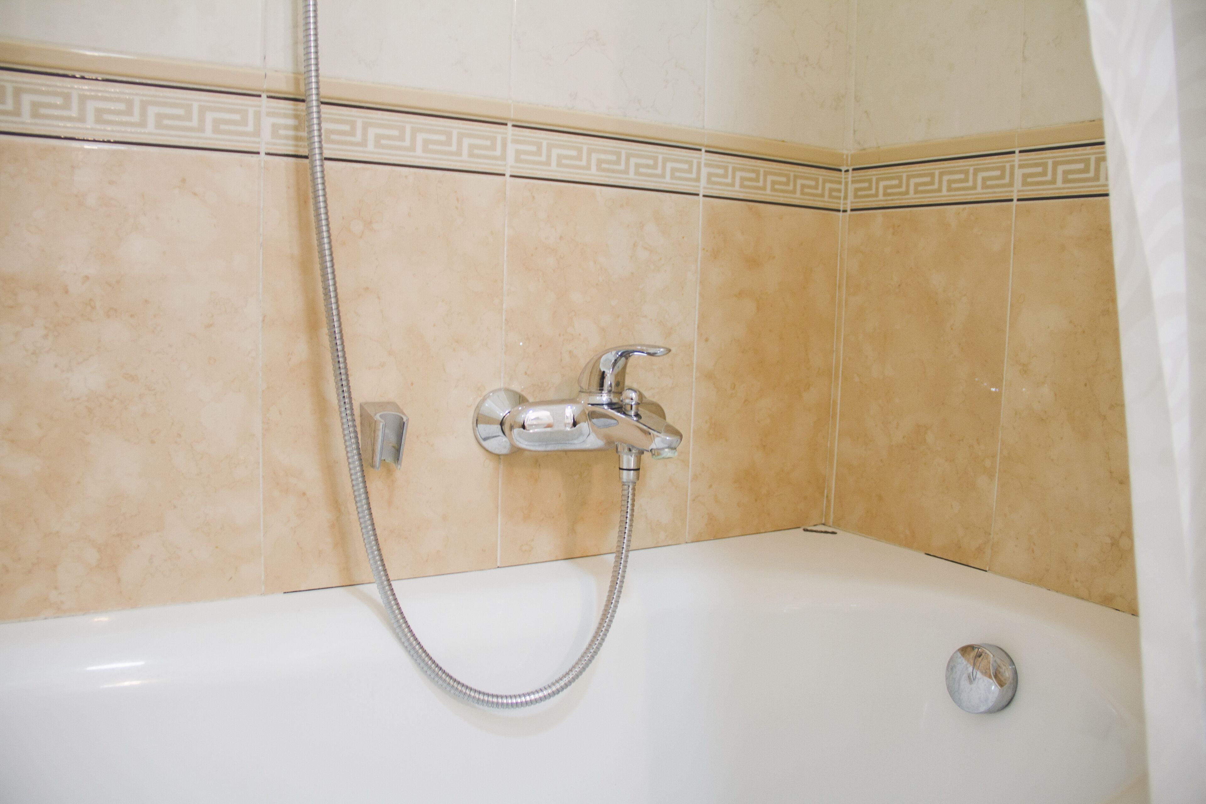 A bathroom with a bathtub, a shower, and a faucet.