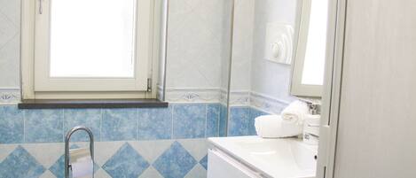 Un baño con inodoro, lavamanos y ventana.
