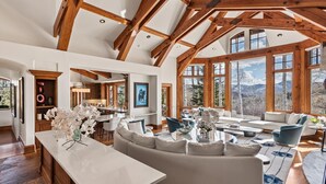 A spacious living area with a large window, a built-in fireplace, and a wooden ceiling. - 5 Bed/ 5.5 Bath Ski-In, Ski-Out  Home in Exclusive Two Creeks Neighborhood (Snowmass Village)