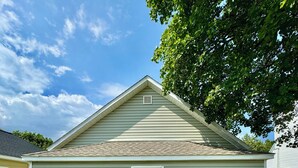 Een gelijkvloers huis met een voordeur, een klein portaal en een pad van stenen dat naar de deur leidt.