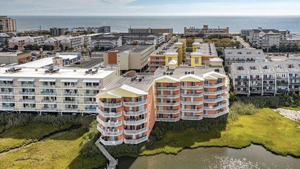 Een hotelcomplex aan de kust met meerdere gebouwen, waaronder een opvallend meerhoog gebouw met balkons.