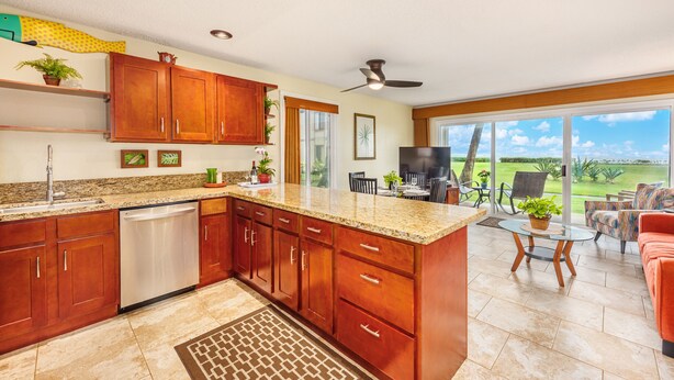A spacious kitchen with wooden cabinets, a built-in dishwasher, and a large island. - Ocean Front, Ground Level 1 Bedroom with King, Sleeps 4, with Cold AC (Kapaʻa)