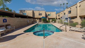 Una piscina con sillones de descanso y un cartel que dice 'No Diving', rodeada de edificios de apartamentos.