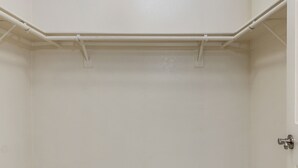 Una habitación blanca con una puerta y un techo blanco con una tubería blanca que lo atraviesa.