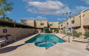 Una piscina con sillones de descanso y un cartel que dice 'No Diving', rodeada de edificios de apartamentos.