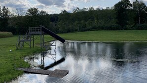 A pond with a wooden deck and a small bridge. - Secluded Cabin w/ Private Pond/ Peaceful Getaway (Cameron Mills)