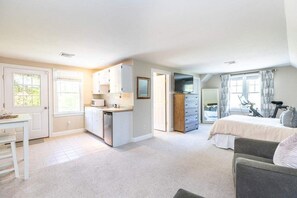 Enjoy a compact room with a kitchenette, a large window offering a view of the outdoors, and a comfortable bed.