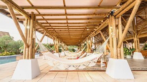 A covered outdoor area with wooden beams and hammocks. - 4-6 guests, 5 Beds / 2.5 Baths • Private Villa / Beachfront Pool & Club (Las Escobas del Venado)