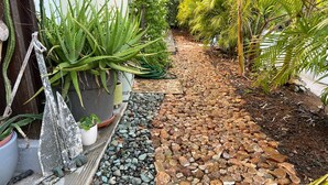 A garden pathway with potted plants and a gravel bed. - 4-6 guests, 5 Beds / 2.5 Baths • Private Villa / Beachfront Pool & Club (Las Escobas del Venado)