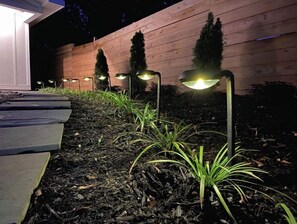 Garden area with trees and plants, adjacent to a building.