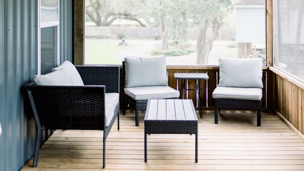 A covered outdoor seating area with wicker furniture and a ceiling fan. - River View Loft on the Mermentau River with pool access (Mermentau)