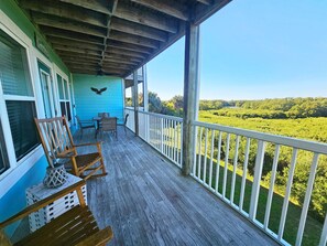 A wooden deck with a view of a green landscape.