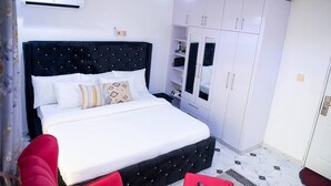 Um quarto com uma cama, um guarda-roupa e um aparelho de ar condicionado.