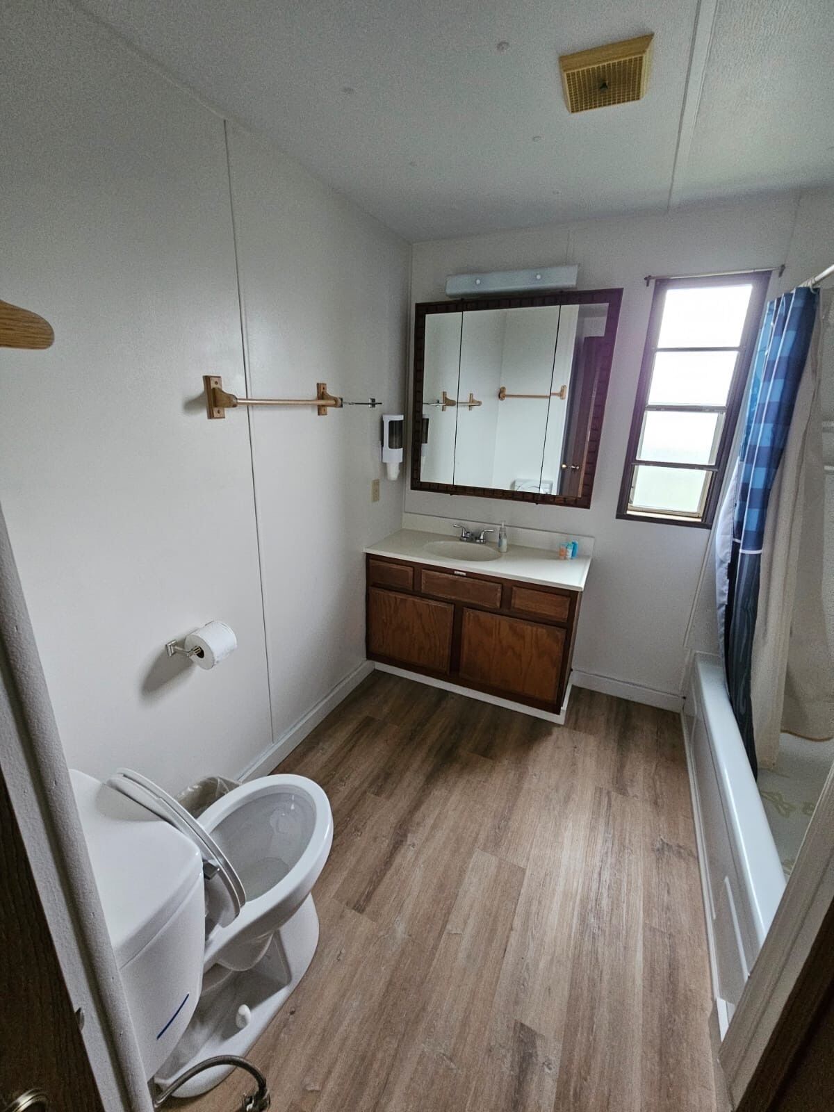 A compact bathroom with a toilet, sink, and mirror.