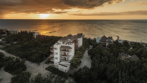 A coastal hotel with multiple buildings, including a prominent white structure with balconies. - Casa Astral Hotel Boutique and Apartments (Isla Holbox)