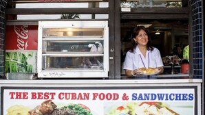 Ein Imbissstand mit einem Schild, das 'The Best Cuban Food & Sandwiches' bewirbt.