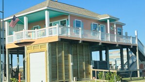 A two-story building with a balcony and a covered area. - Home with beach view from  porch and it’s only a two minute walk to the beach. (Crystal Beach)