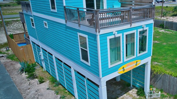 A two-story house with a balcony and a sign indicating a 'Pineapple Paradise'. - Comfy King beds, close to beach, pool + pet friendly  (Eastpoint)
