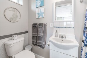 A bathroom with a toilet, sink, and towel rack.