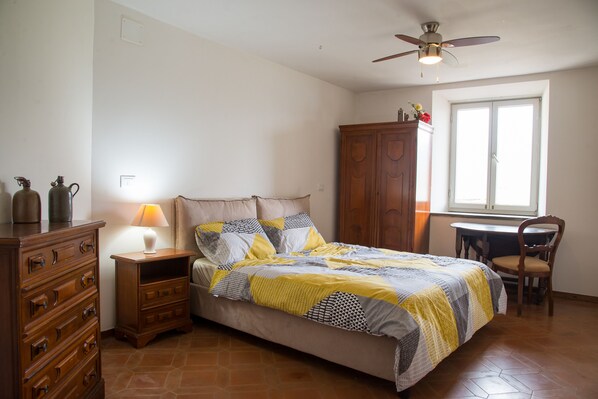 Un dormitorio con una cama, un aparador de madera, un escritorio y una silla.