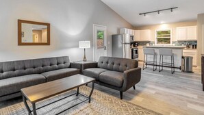 Una sala de estar moderna con un sofá modular, una mesa de centro y un tapete estampado.