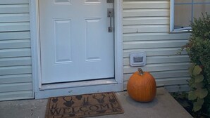 A front door with a doormat, a mailbox, and a lit exterior light. - Walking distance to Baum Stadium & Razorback Greenway access across the street! (Fayetteville)