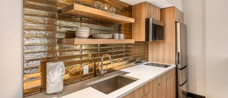 Una cocina moderna con refrigerador de acero inoxidable, armarios de madera, pileta doble y un salpicadero decorativo.