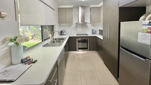 A modern kitchen with stainless steel appliances, a built-in oven, and a large refrigerator.