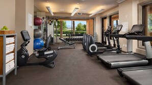 Een sportschool met loopbanden, elliptische trainers en gewichthefapparatuur.