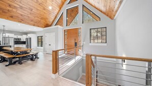 Une cuisine spacieuse équipée d’appareils modernes, un coin repas avec une table en bois et un escalier menant à l’étage supérieur.