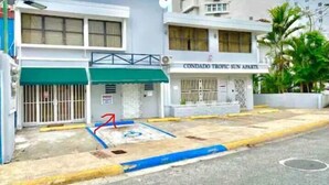 A building with a sign reading "CONDADO TROPIC SUN PARTS".