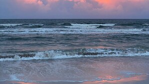 Una playa con olas y un cielo nublado.