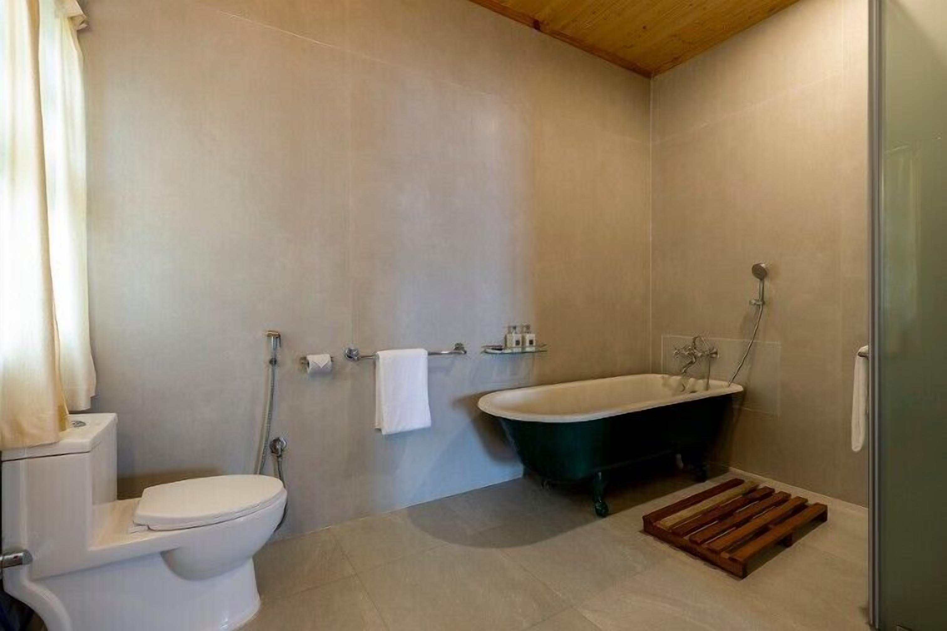 Een badkamer met een toilet, een badkuip en een douche.