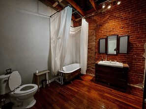 Een bad/douchecombinatie, een bidet, handdoeken, zeep