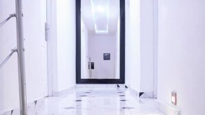 Ein moderner Hotel-Flur mit Marmorstufen und einem Metallgeländer.