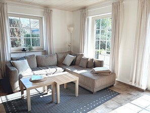 A living room with a sofa, a coffee table, and a lamp.
