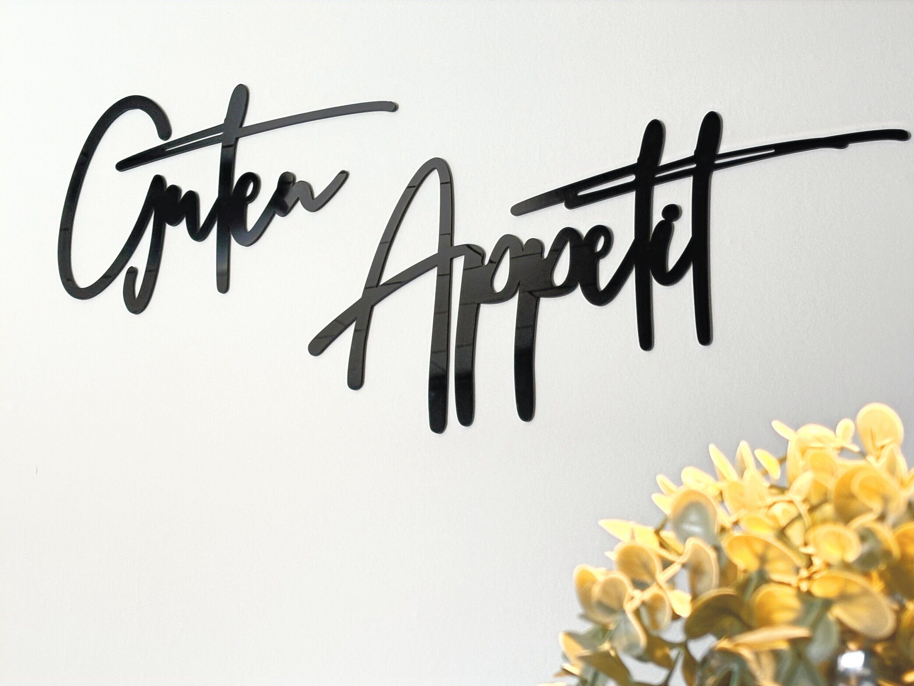 A wall with the words 'Cuteness Appetit' in a stylized font.