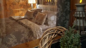 Ein gemütliches Zimmer mit einem Bett, einer Lampe und einer Kerze auf einem Tisch.