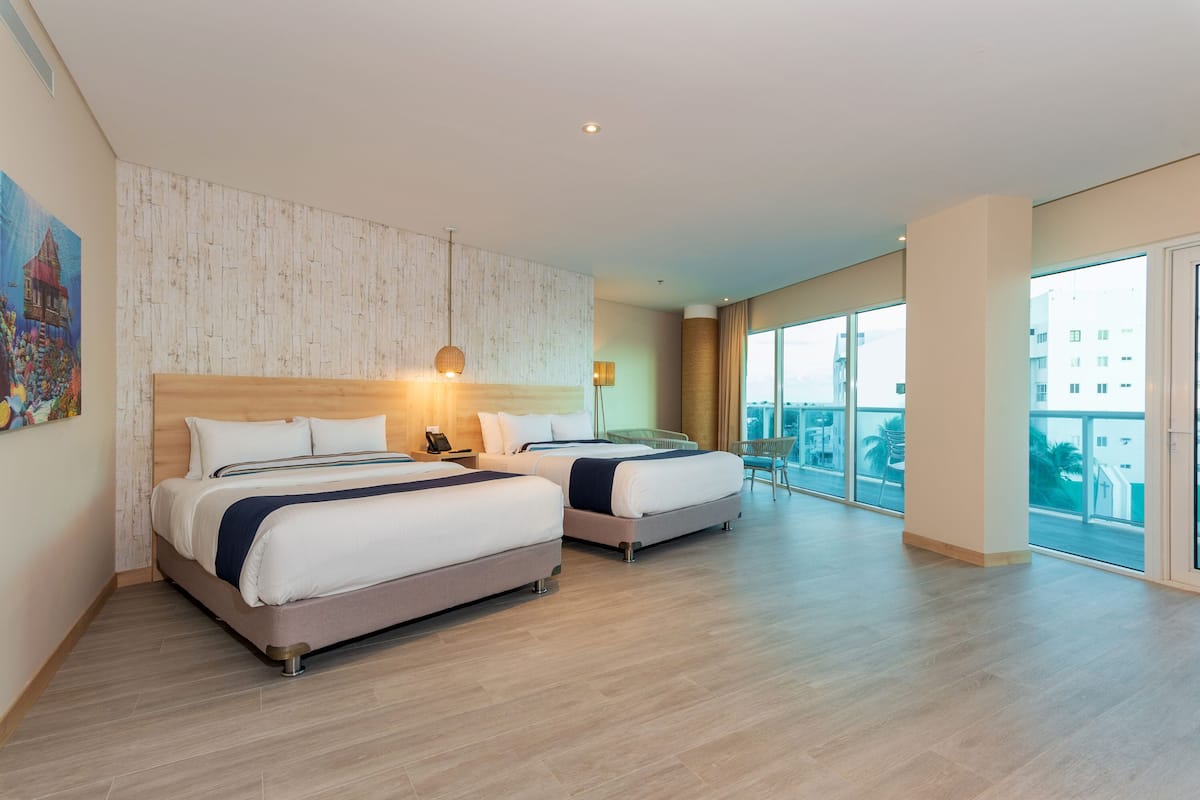 Une chambre d’hôtel moderne avec deux lits, une grande fenêtre et une vue sur la ville.