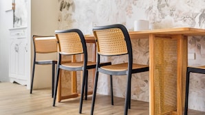 A dining area with a wooden table and four chairs with woven backs. - Lane 32 (Tainan)