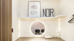 A modern bathroom with a wooden vanity, a round mirror, and a framed motivational quote. - Lane 32 (Tainan)
