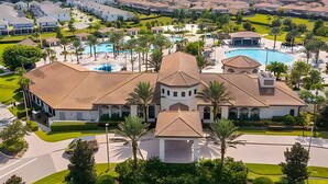A large, multi-story house with a swimming pool and a tennis court.