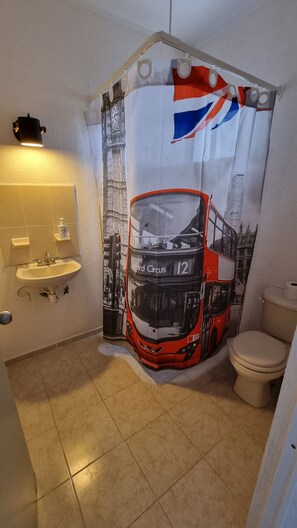 A bathroom with a double bus shower curtain, a sink, and a toilet. - Cookie House Cancun Mex (Cancun)