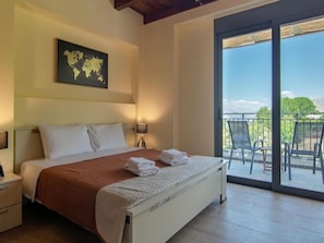Relax in a serene bedroom with a large bed, world map, and sliding glass door leading to an outdoor patio.