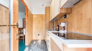 Une cuisine moderne avec des meubles en bois, un plan de travail en marbre et un four encastré.